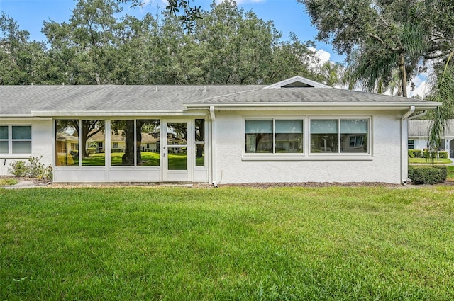 rear view of property with a sunroom and a lawn