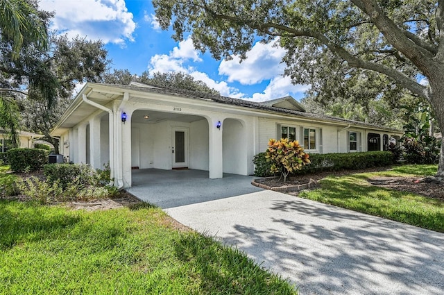 ranch-style home featuring cooling unit and a carport