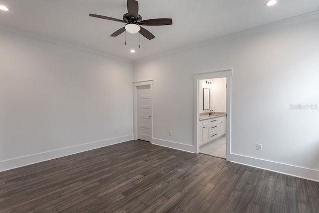 unfurnished bedroom with sink, ensuite bath, dark hardwood / wood-style flooring, ornamental molding, and ceiling fan