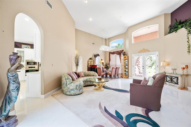 living room with a high ceiling and french doors