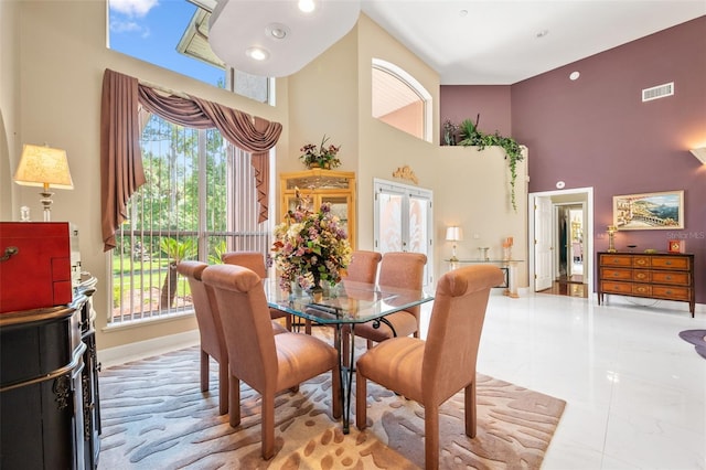 dining room featuring a high ceiling, french doors, and a wealth of natural light