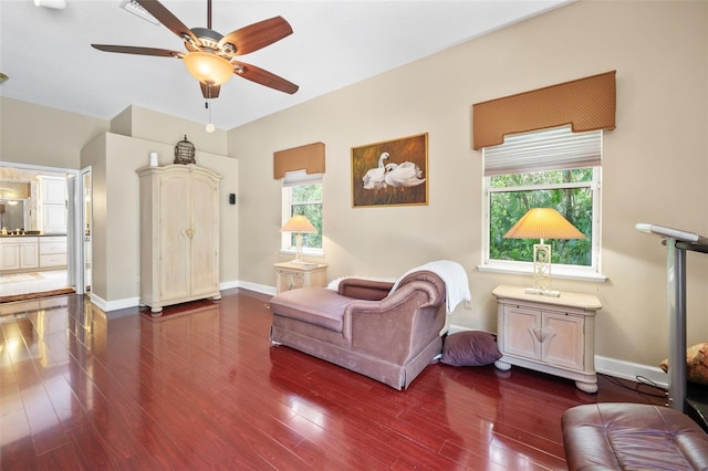 living area featuring ceiling fan and dark wood-type flooring