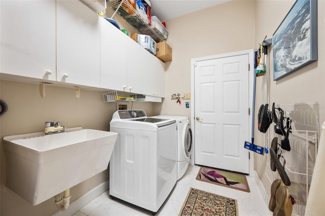 washroom with washer and clothes dryer, cabinets, light tile patterned floors, and sink