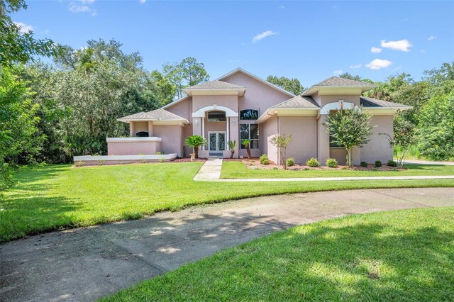 mediterranean / spanish-style home with french doors and a front yard