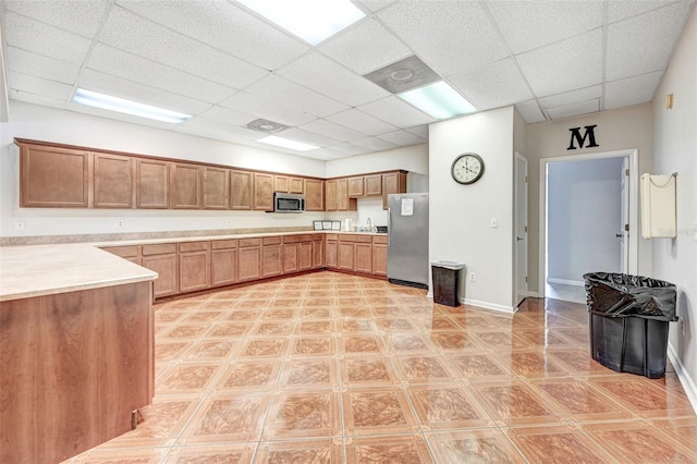 kitchen with a drop ceiling and appliances with stainless steel finishes