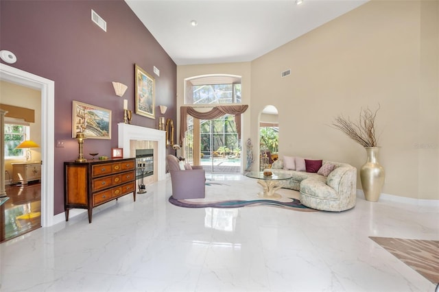 sitting room with a tiled fireplace and a towering ceiling