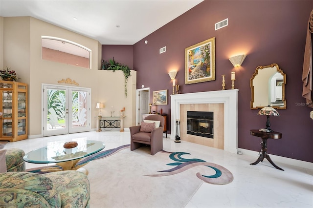 living room featuring a tile fireplace and a high ceiling