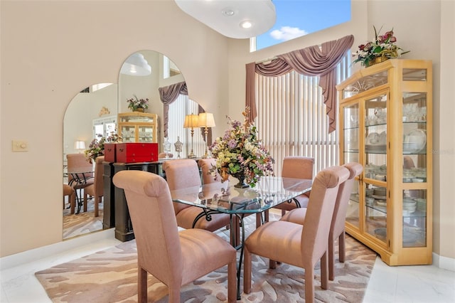 dining space featuring a towering ceiling