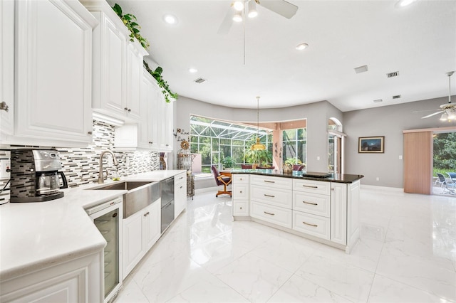 kitchen with decorative backsplash, pendant lighting, white cabinetry, and beverage cooler