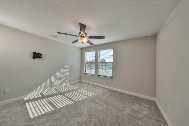 carpeted spare room with a textured ceiling and ceiling fan