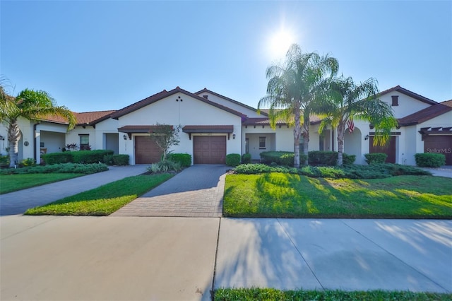 16850 Whisper Elm St, Wimauma, FL 33598 - view of front facade with a garage, driveway, stucco siding, and a front lawn