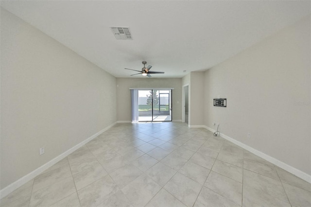 empty room with ceiling fan and light tile patterned floors