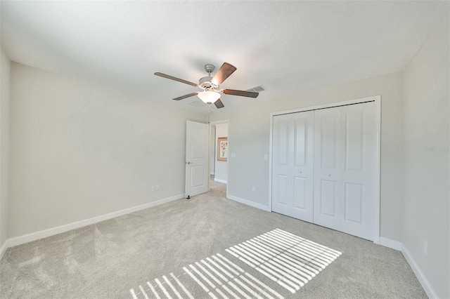 unfurnished bedroom with ceiling fan, a closet, and light carpet