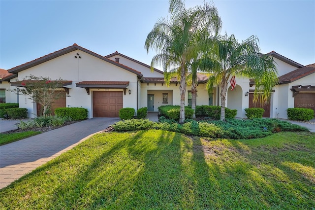 16850 Whisper Elm St, Wimauma, FL 33598 - mediterranean / spanish home with driveway, an attached garage, stucco siding, and a front lawn