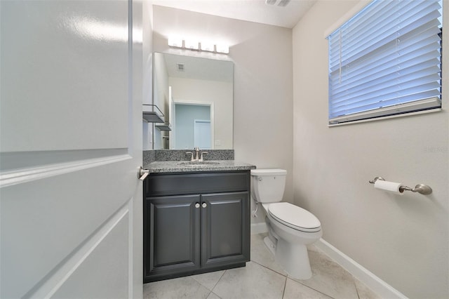 bathroom with visible vents, toilet, vanity, baseboards, and tile patterned floors