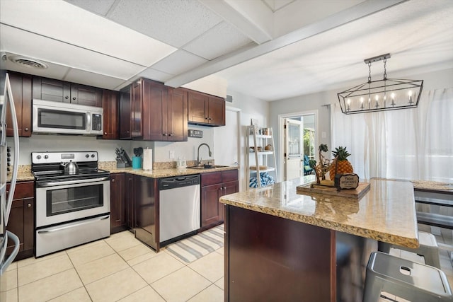 kitchen featuring hanging light fixtures, stainless steel appliances, sink, a notable chandelier, and light tile patterned floors