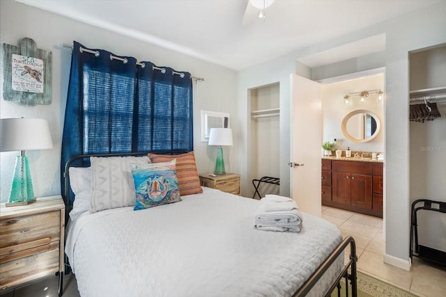 tiled bedroom featuring connected bathroom, ceiling fan, a closet, and sink