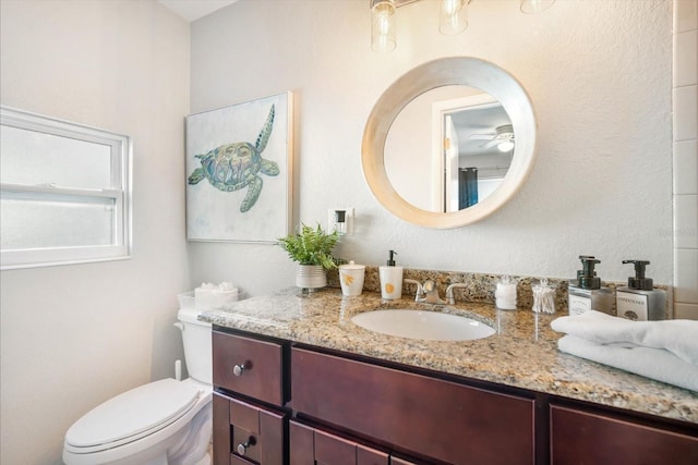 bathroom featuring vanity, toilet, and ceiling fan