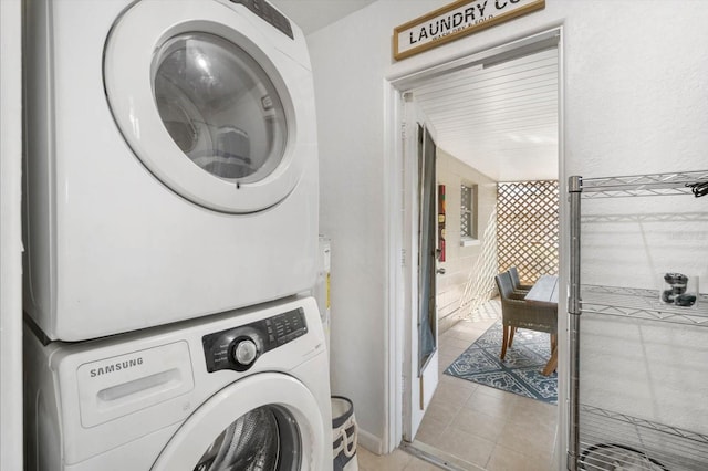 laundry area featuring light tile patterned floors and stacked washer and clothes dryer