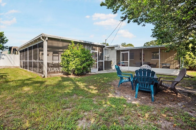 back of property with a lawn and a sunroom