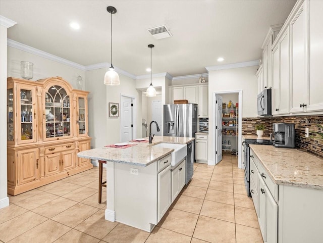 kitchen featuring an island with sink, tasteful backsplash, white cabinets, stainless steel appliances, and ornamental molding