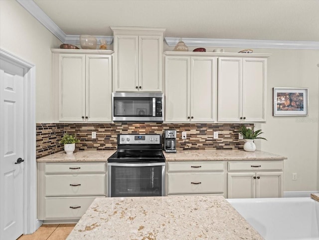 kitchen featuring light stone counters, white cabinets, appliances with stainless steel finishes, light tile patterned floors, and crown molding