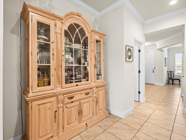 hallway featuring ornamental molding and light tile patterned floors