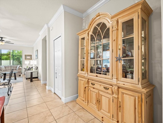 interior space featuring crown molding, light tile patterned flooring, and ceiling fan