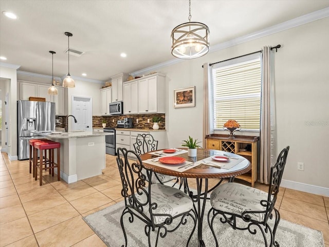 dining room featuring ornamental molding, a chandelier, light tile patterned floors, and sink