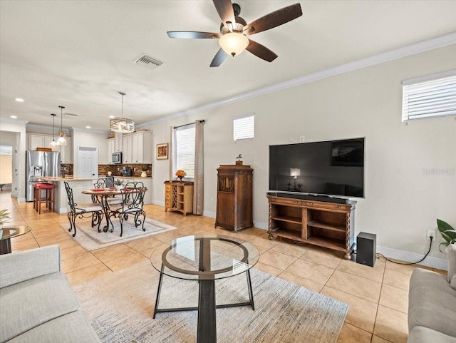 tiled living room with ornamental molding and ceiling fan