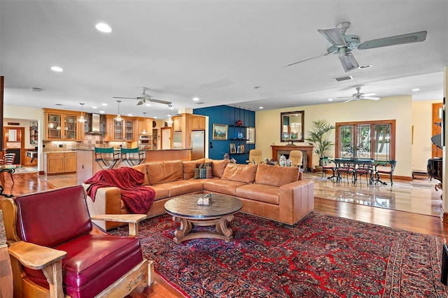 living room featuring light hardwood / wood-style flooring and ceiling fan