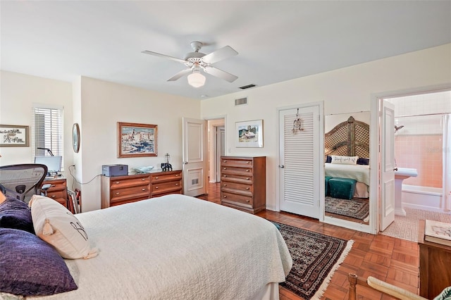 bedroom featuring ceiling fan, parquet floors, and ensuite bathroom