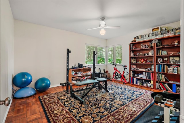 exercise room featuring parquet flooring and ceiling fan