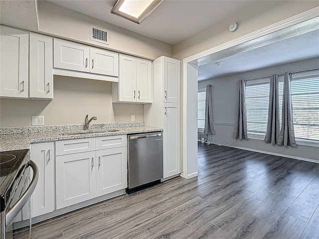 kitchen featuring light wood finished floors, visible vents, white cabinets, stainless steel appliances, and a sink