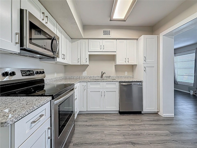 kitchen featuring appliances with stainless steel finishes, visible vents, and white cabinets