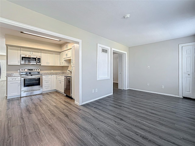 kitchen with wood finished floors, white cabinetry, open floor plan, light countertops, and appliances with stainless steel finishes