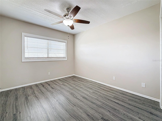 unfurnished room featuring a textured ceiling, ceiling fan, dark wood-type flooring, and baseboards