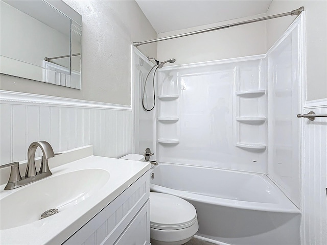 full bathroom with shower / bath combination, vanity, toilet, and wainscoting