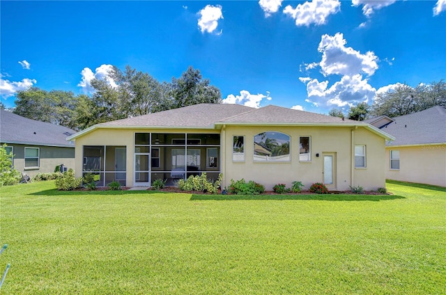 rear view of house featuring a lawn and a sunroom