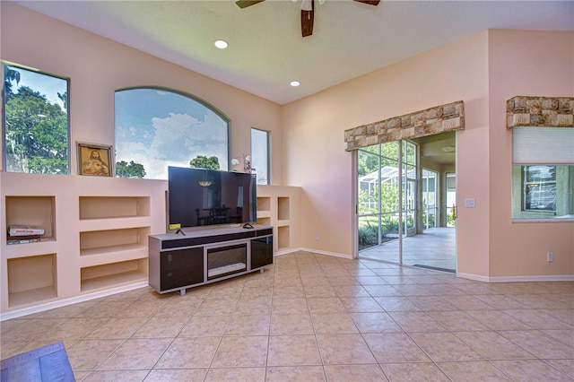 living room with ceiling fan, built in features, light tile patterned floors, and a high ceiling