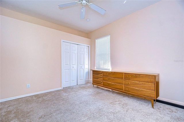 unfurnished bedroom featuring ceiling fan, a closet, and light carpet