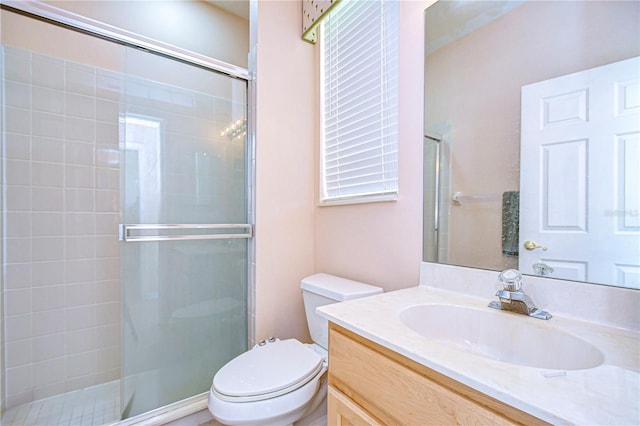 bathroom featuring vanity, toilet, and an enclosed shower