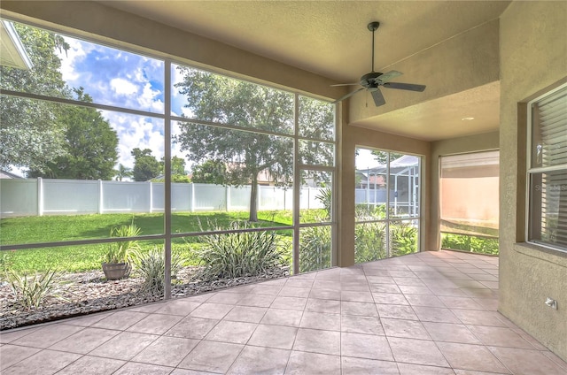 unfurnished sunroom with ceiling fan