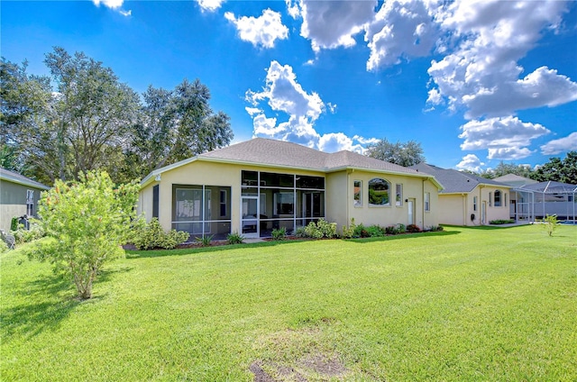 back of house with a sunroom and a yard