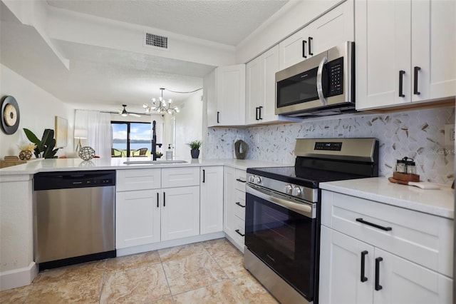 kitchen with appliances with stainless steel finishes, decorative backsplash, white cabinets, and a textured ceiling