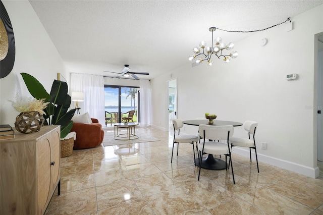 dining space featuring a textured ceiling and ceiling fan with notable chandelier