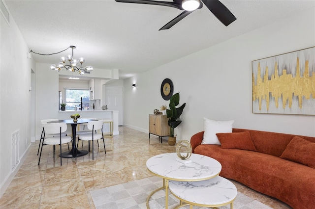 living room with ceiling fan with notable chandelier