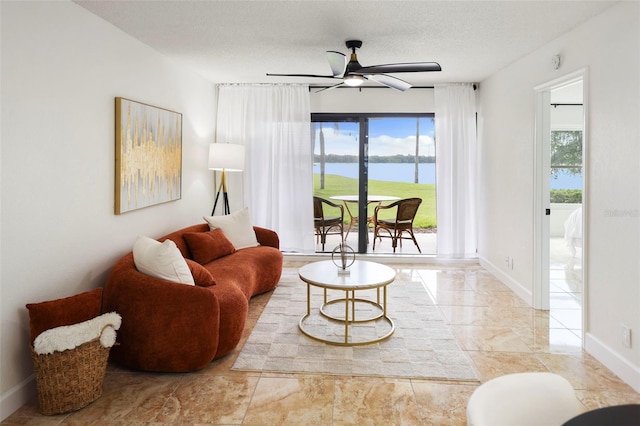 6291 Bahia Del Mar Cir Unit 103, Saint Petersburg, FL 33715 - living room featuring baseboards, a ceiling fan, a water view, and plenty of natural light