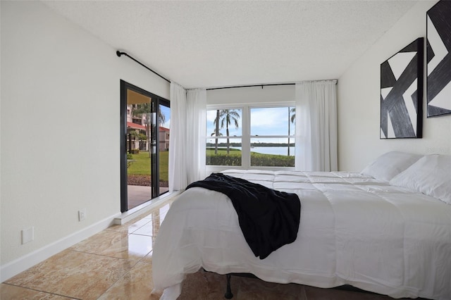 bedroom with a textured ceiling and light tile patterned floors