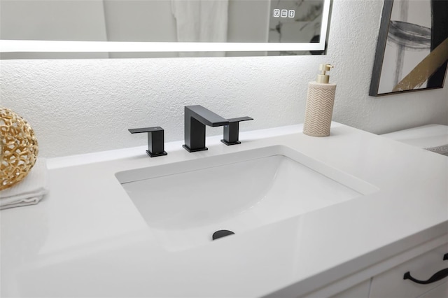 interior details with vanity and a textured ceiling